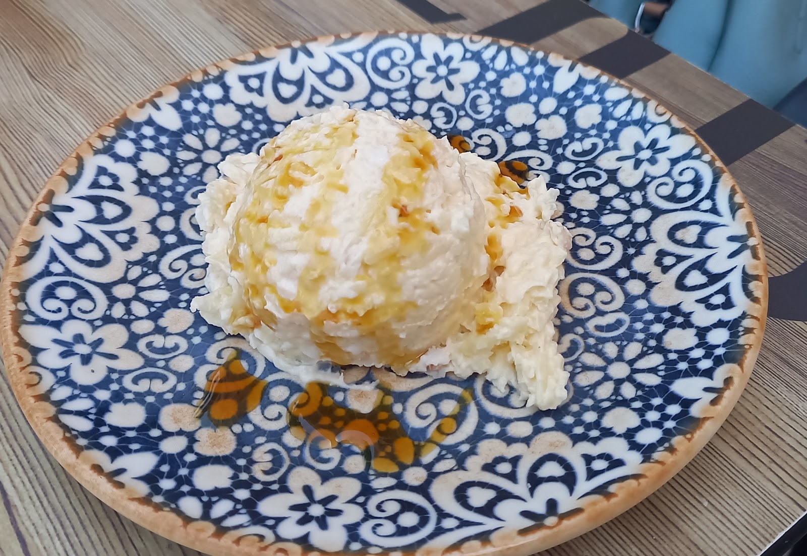 Ensaladilla con queso rallado y un hilo de salsa oscura